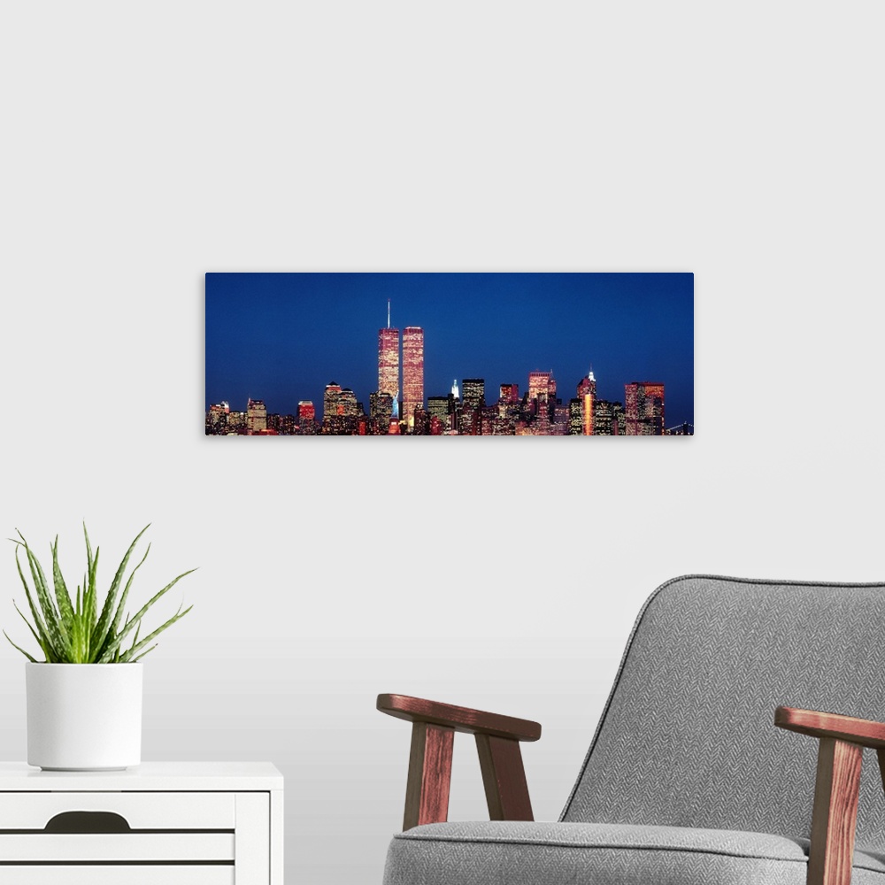 A modern room featuring Giant panoramic photograph of New York City skyscrapers at night, including the World Trade Center.