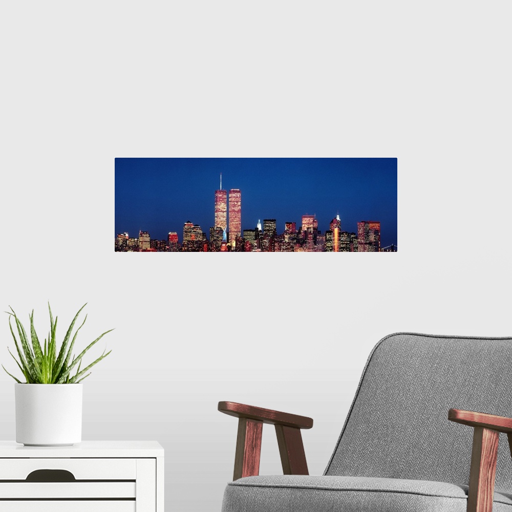 A modern room featuring Giant panoramic photograph of New York City skyscrapers at night, including the World Trade Center.
