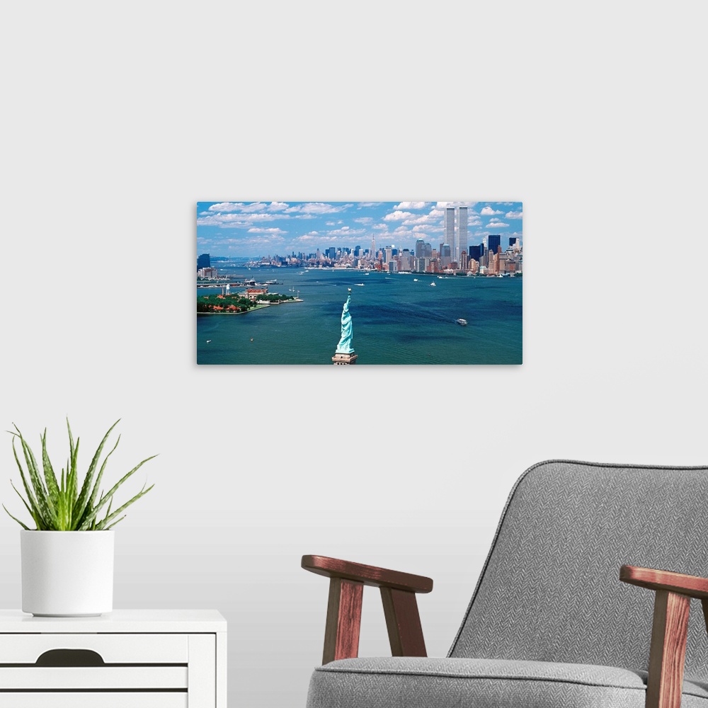 A modern room featuring Panoramic wall art of Manhattan, Ellis Isle, and Hudson River photographed from south of the Stat...