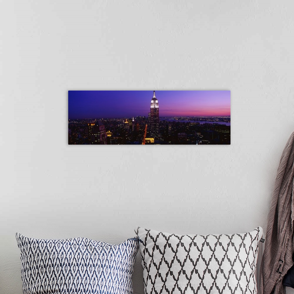 A bohemian room featuring This is a panoramic photograph of the Manhattan skyline at night contrasting with a dramatic and ...