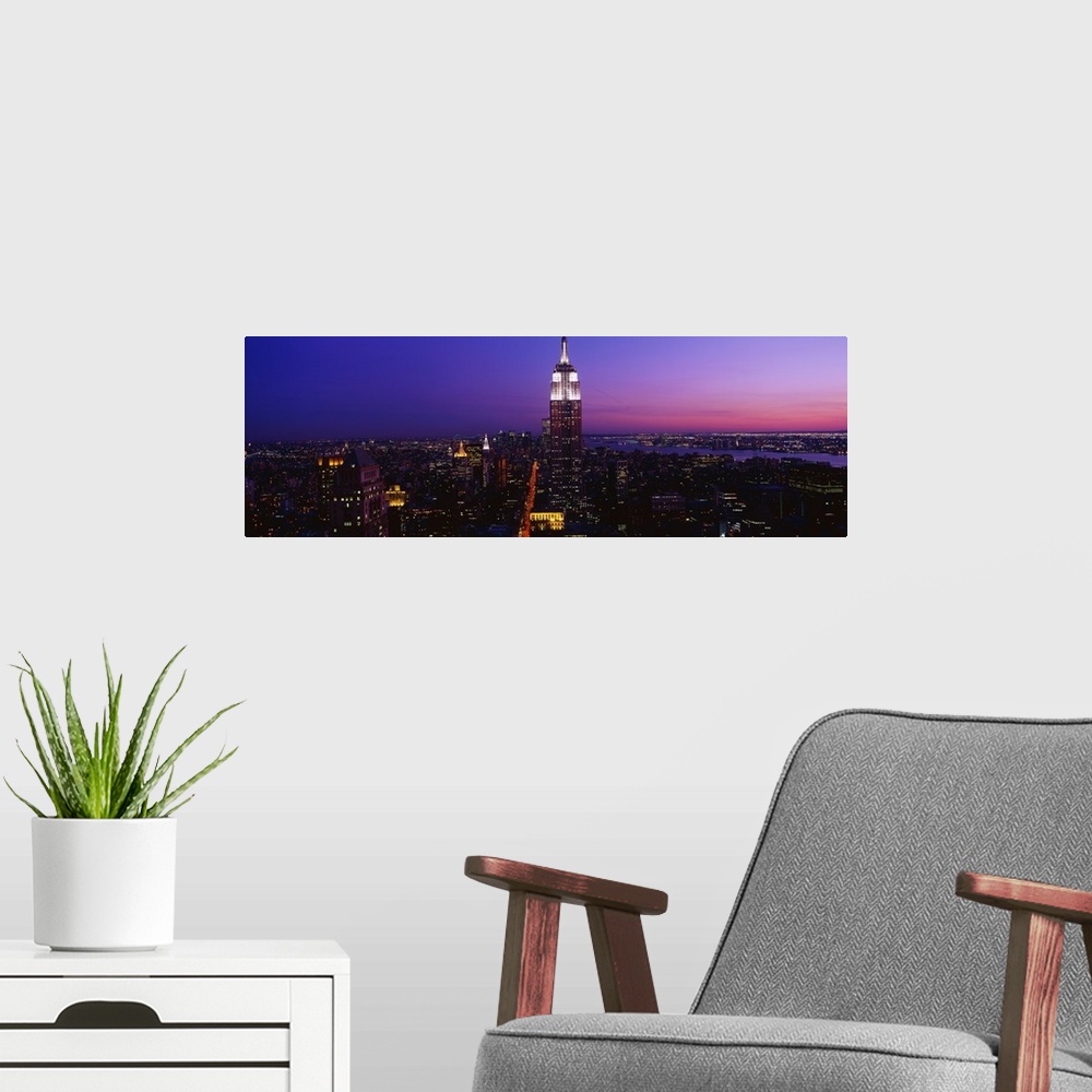 A modern room featuring This is a panoramic photograph of the Manhattan skyline at night contrasting with a dramatic and ...