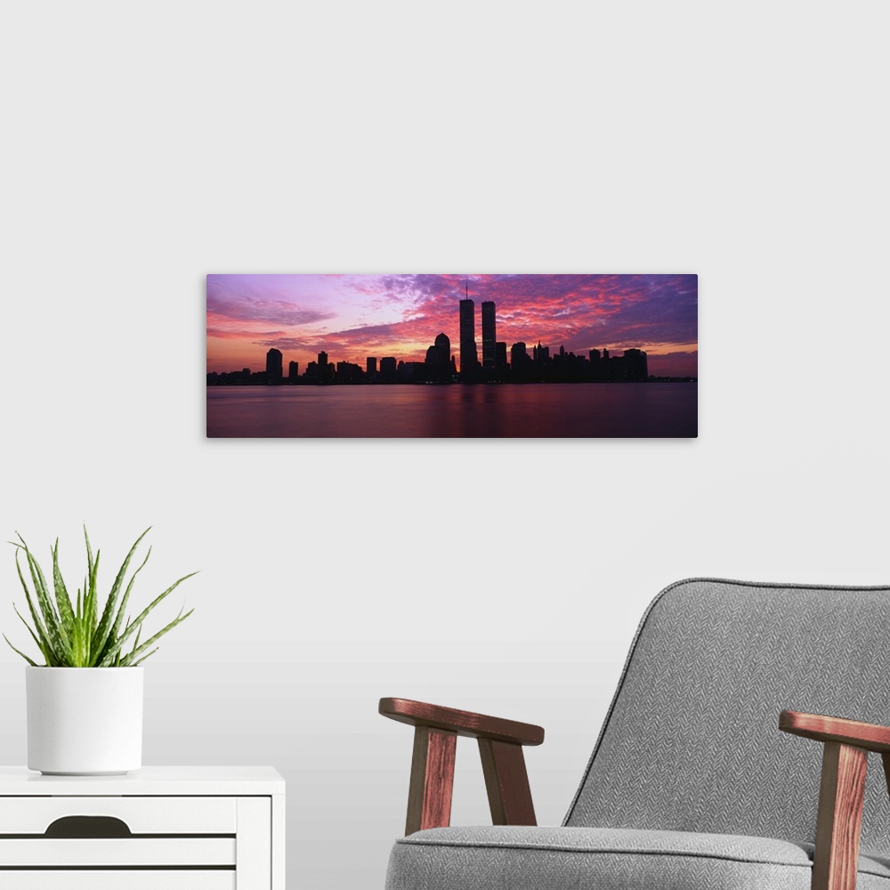 A modern room featuring Dramatic photograph of the New York City skyline at sunset, with the World Trade Center towers si...