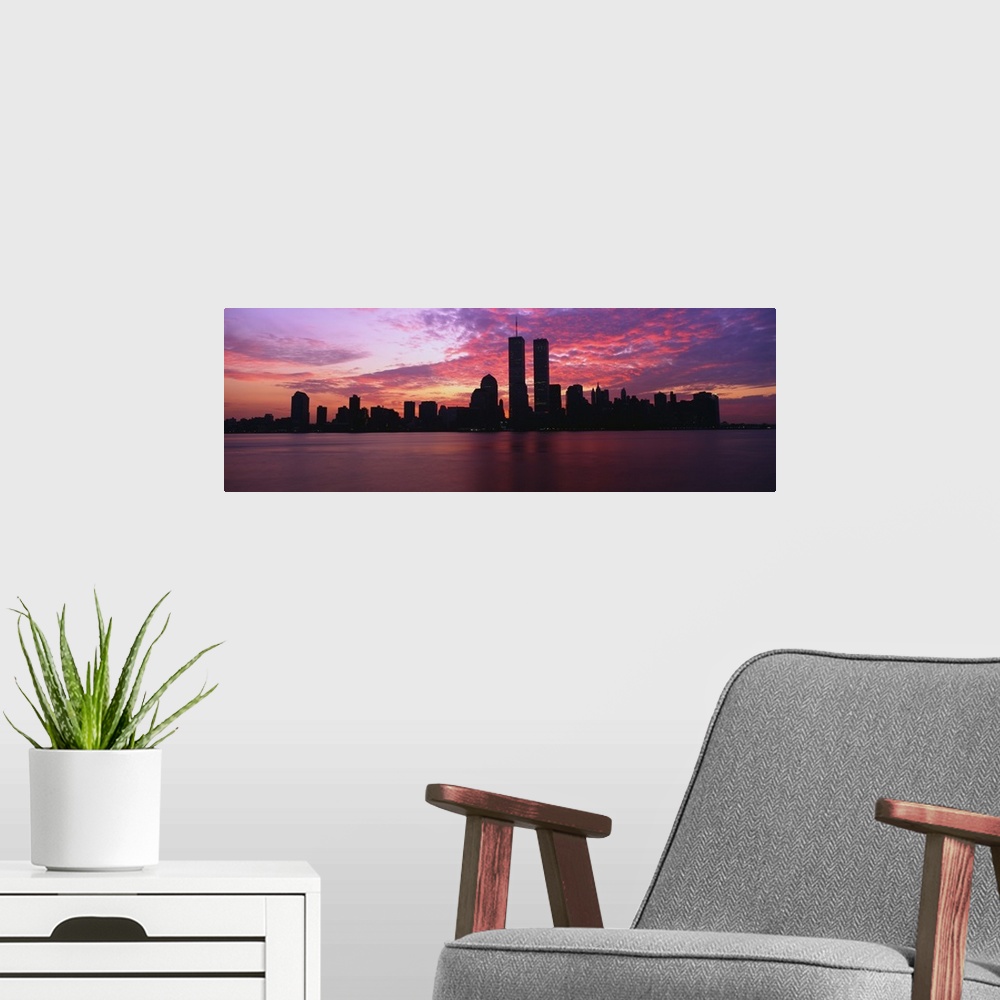 A modern room featuring Dramatic photograph of the New York City skyline at sunset, with the World Trade Center towers si...