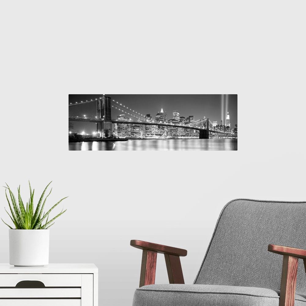 A modern room featuring A panoramic landscape photo taken after 2001 of Manhattan and Brooklyn Bridge shining bright over...