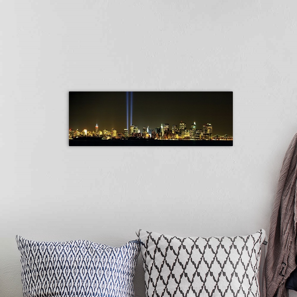 A bohemian room featuring Panoramic photograph displays the Tribute in Light shining brightly in the middle of various skys...