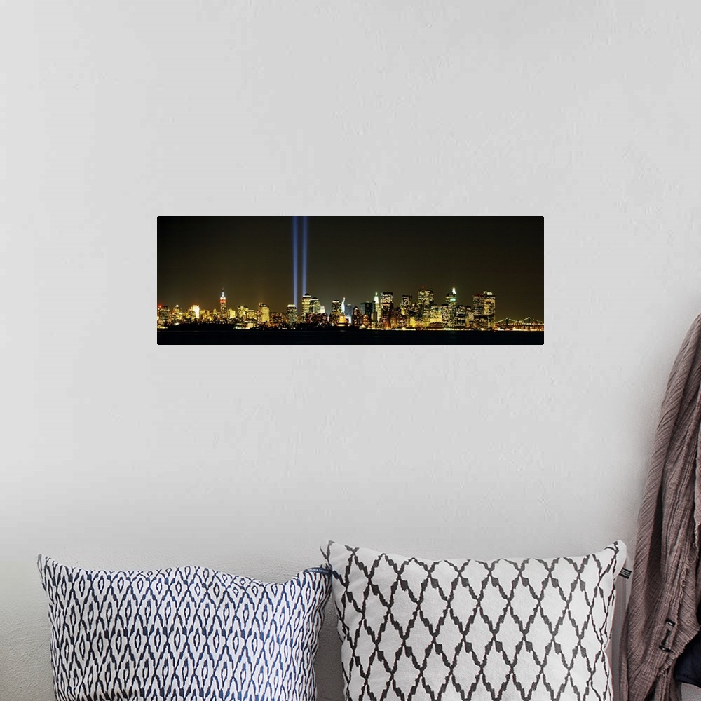 A bohemian room featuring Panoramic photograph displays the Tribute in Light shining brightly in the middle of various skys...