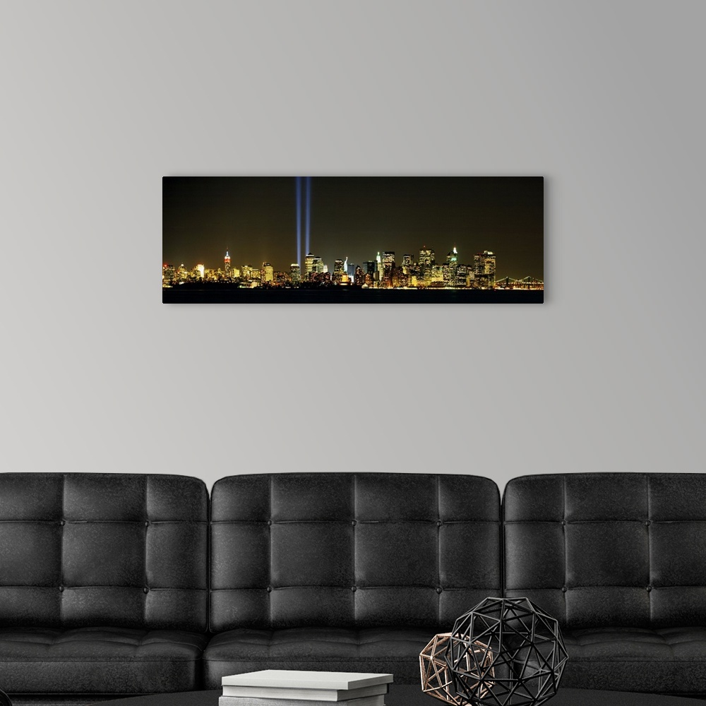A modern room featuring Panoramic photograph displays the Tribute in Light shining brightly in the middle of various skys...