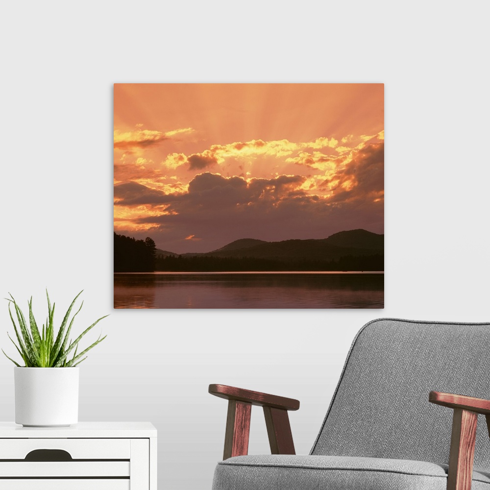 A modern room featuring New York State, Adirondack Mountains, Rollins Pond, Sunlight and moody sky over the mountain and ...