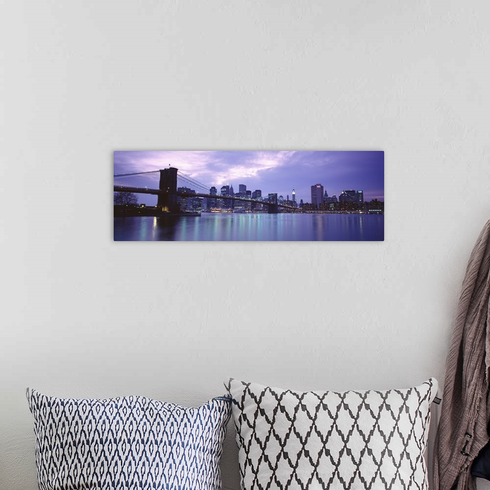 A bohemian room featuring Large, panoramic photograph of the New York skyline, lit up at night, the Brooklyn Bridge in the ...
