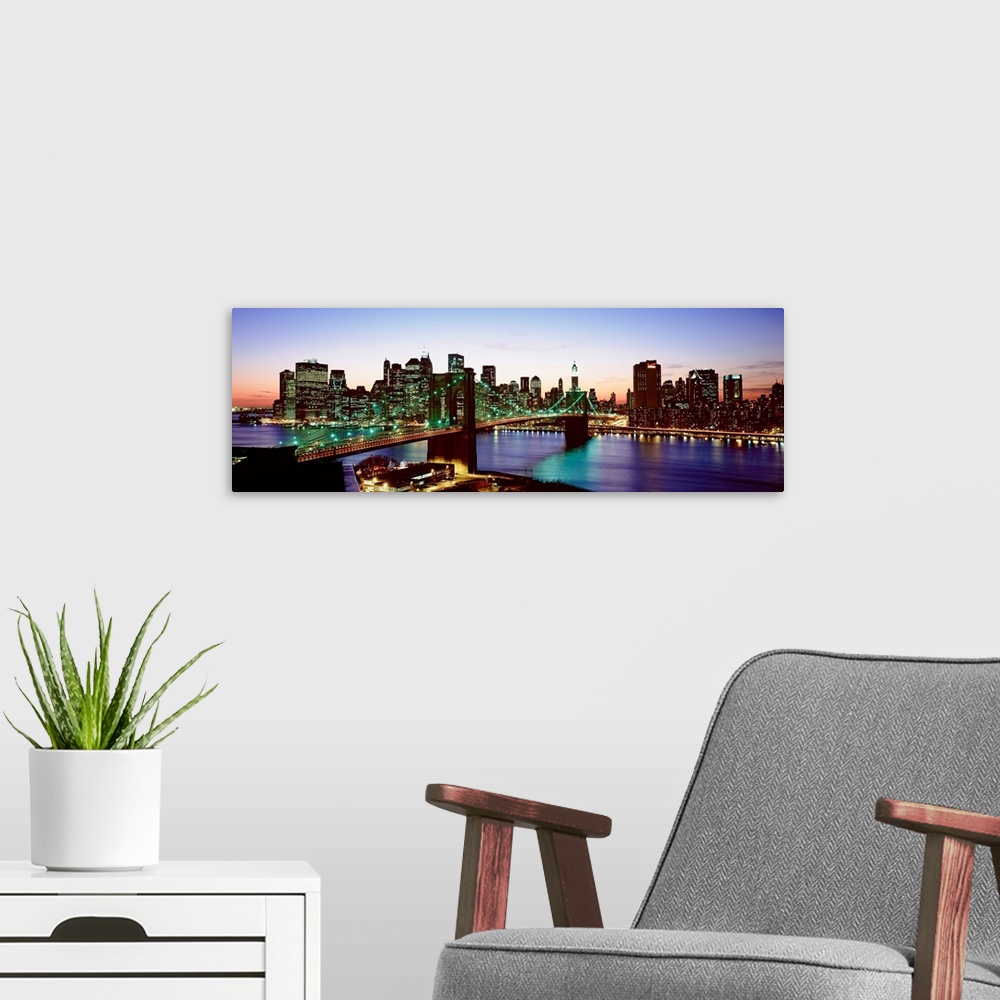 A modern room featuring This panoramic photograph shows the entire Brooklyn Bridge and the bottom of the island of Manhat...