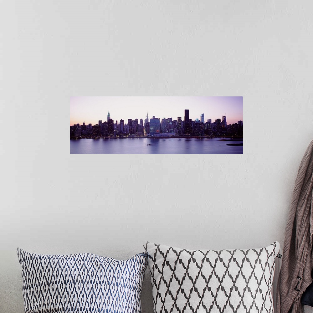 A bohemian room featuring Panoramic wall docor of the New York City cityscape along a waterfront at sunset.