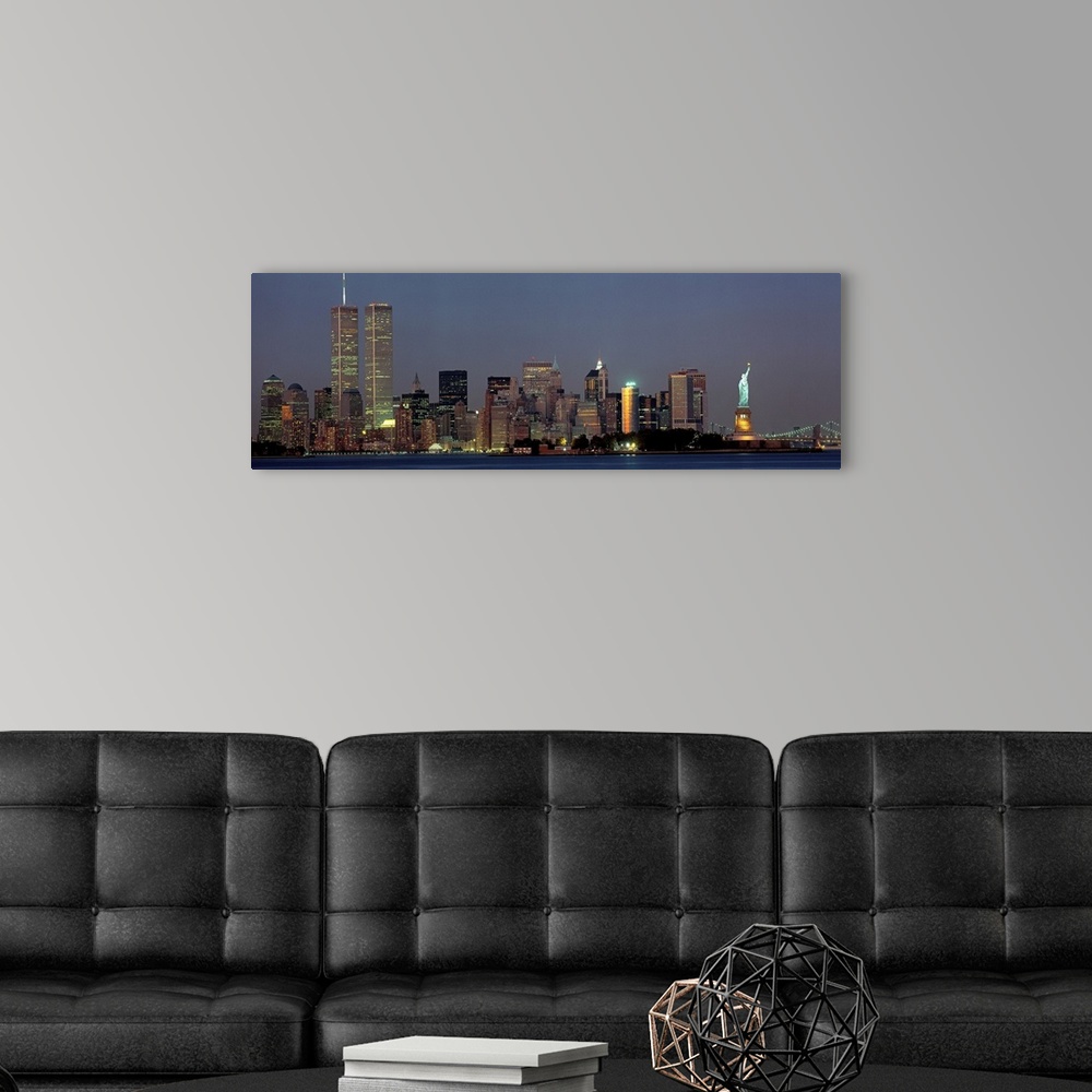 A modern room featuring Panoramic photograph of the New York skyline at night, with the Twin Towers and the Statue of Lib...
