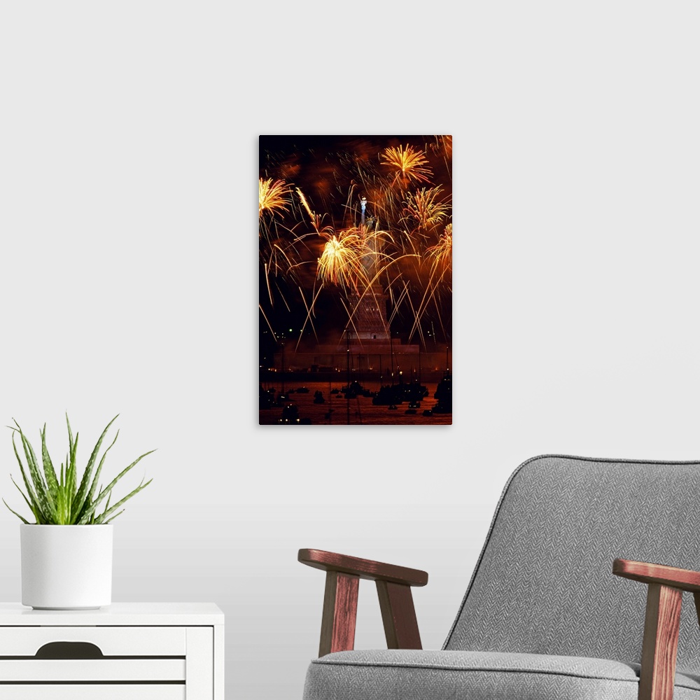 A modern room featuring Vertical, oversized photograph of fireworks exploding in front of the Statue of Liberty, as many ...