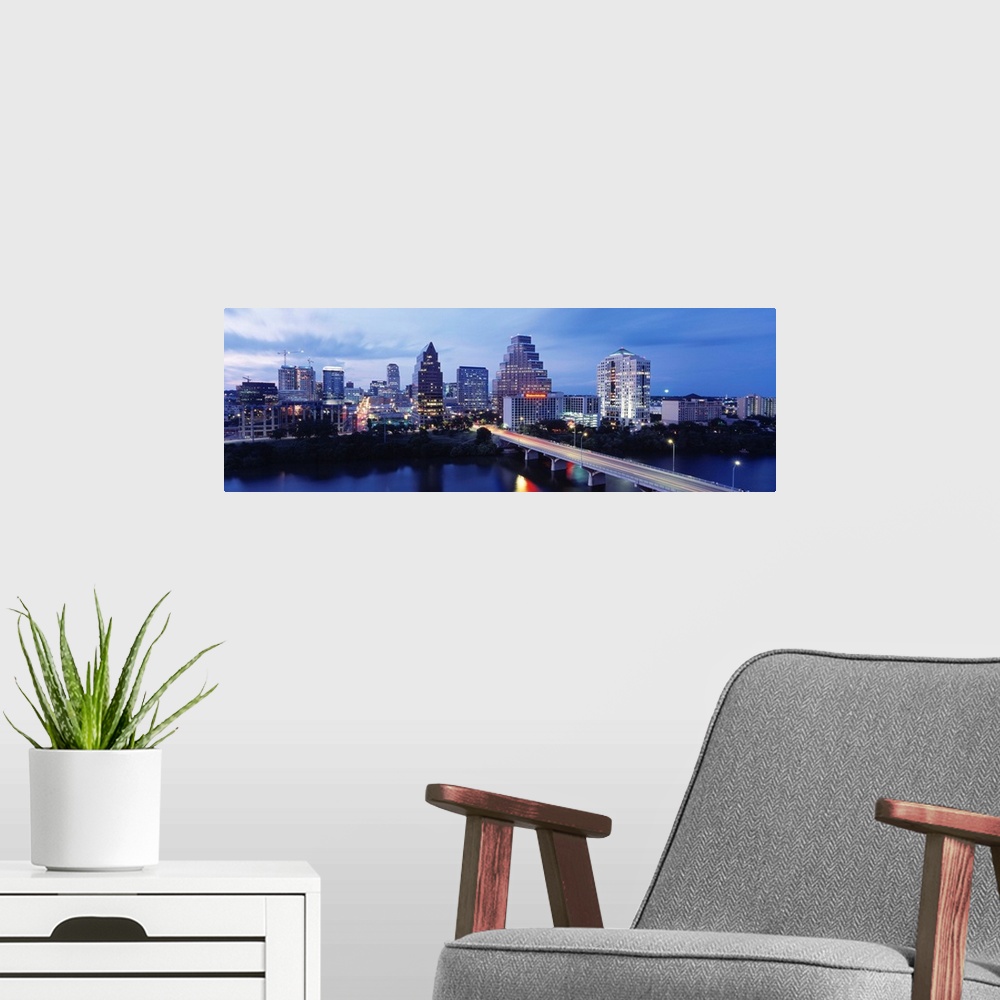 A modern room featuring Panoramic photograph taken within the capital city of Texas shows the skyline at nighttime sittin...