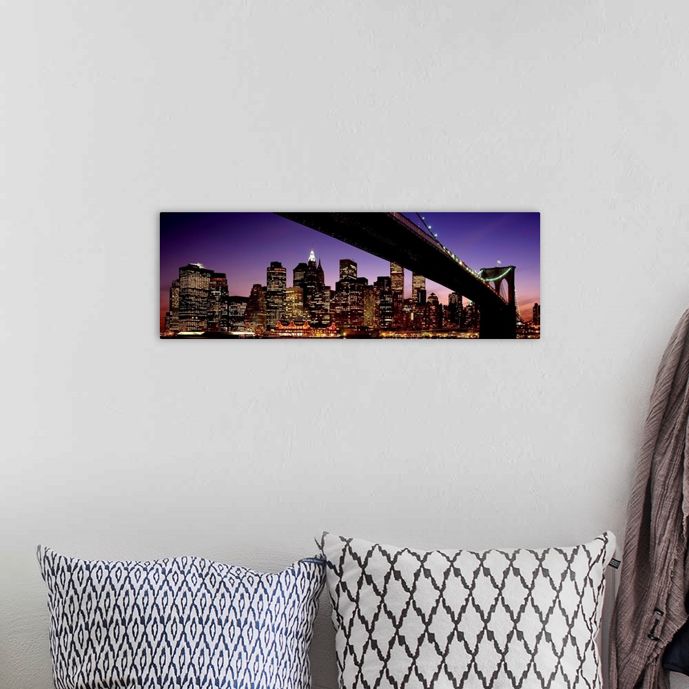 A bohemian room featuring The view of the Manhattan skyline taken from under the Brooklyn Bridge at night.