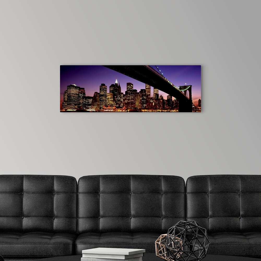 A modern room featuring The view of the Manhattan skyline taken from under the Brooklyn Bridge at night.