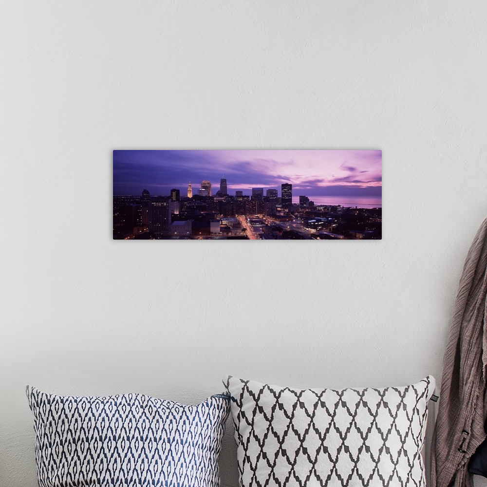 A bohemian room featuring Panoramic photograph of skyline with buildings lit up under a dark cloudy sky.