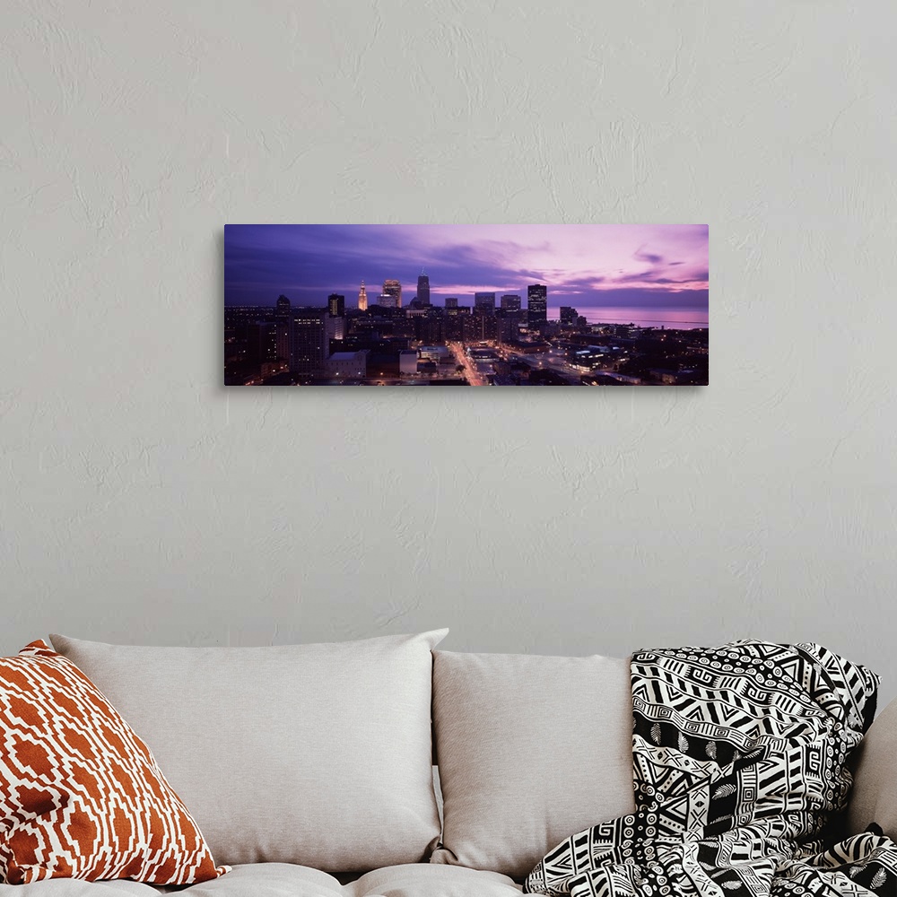 A bohemian room featuring Panoramic photograph of skyline with buildings lit up under a dark cloudy sky.