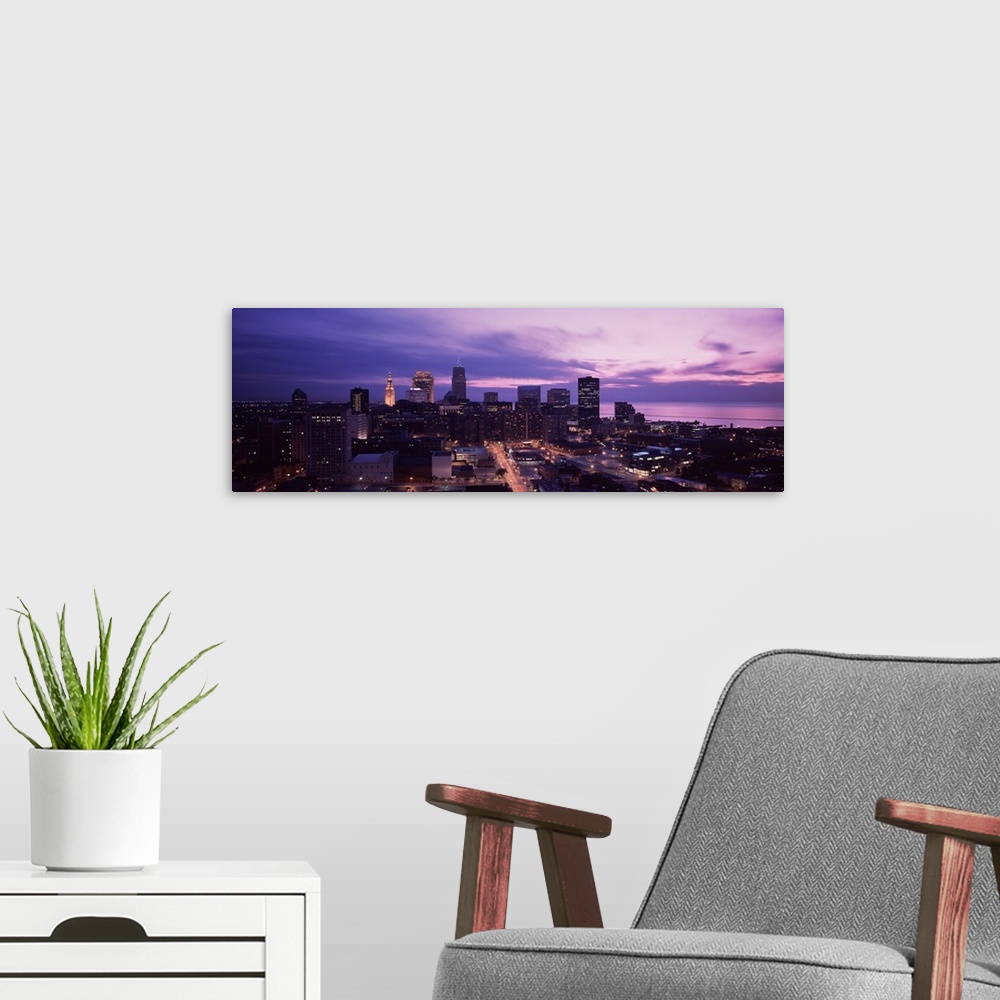 A modern room featuring Panoramic photograph of skyline with buildings lit up under a dark cloudy sky.