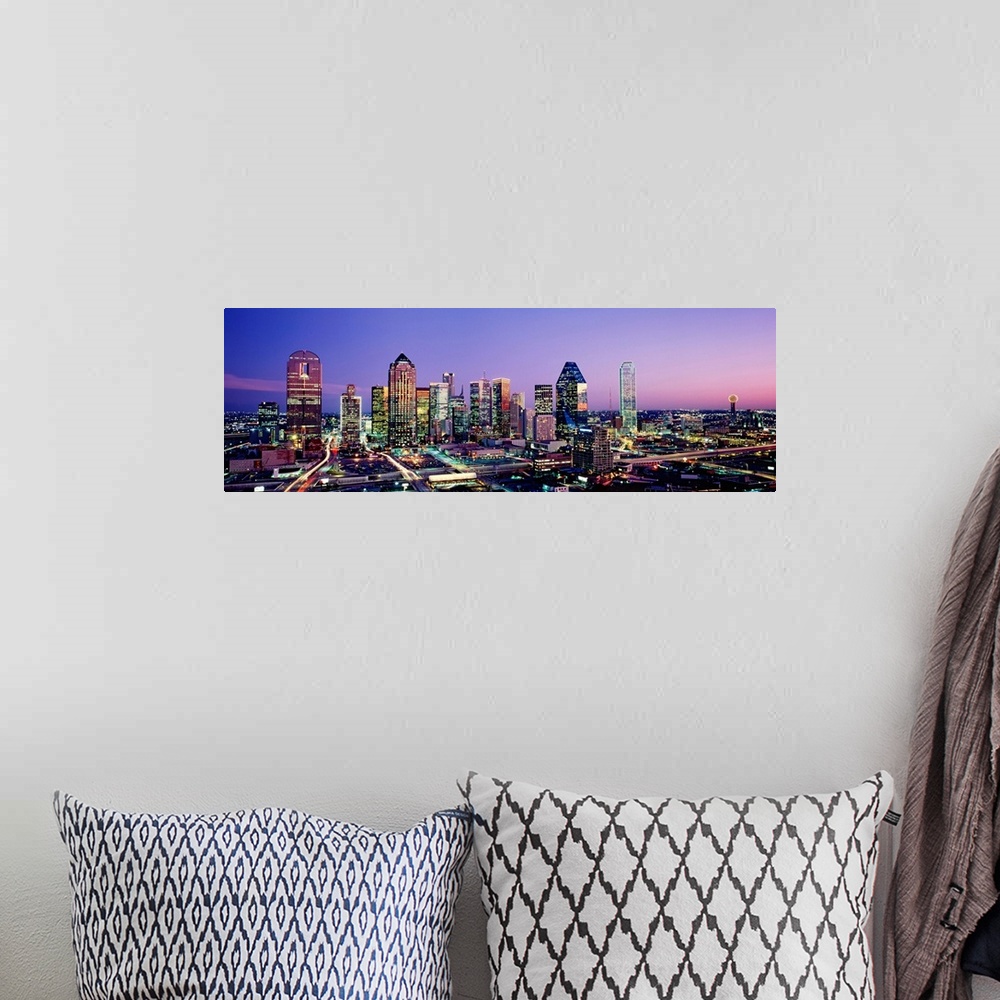 A bohemian room featuring Panoramic photograph displays the busy skyline of Dallas, Texas at night.  The bright lights of t...