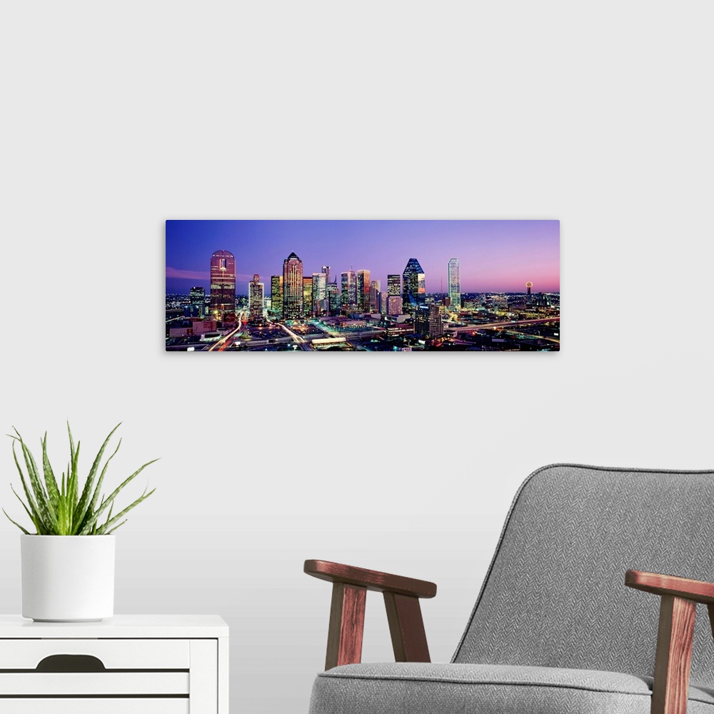 A modern room featuring Panoramic photograph displays the busy skyline of Dallas, Texas at night.  The bright lights of t...