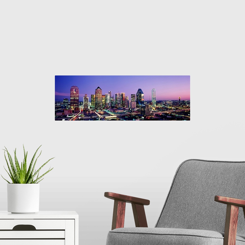 A modern room featuring Panoramic photograph displays the busy skyline of Dallas, Texas at night.  The bright lights of t...