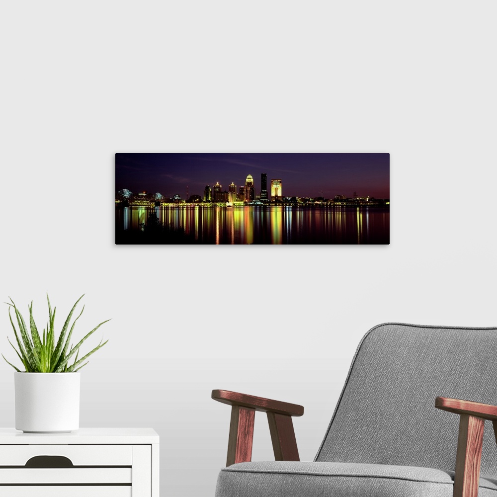 A modern room featuring Panoramic photograph displays the radiantly shining skyline of the largest city in Kentucky at ni...