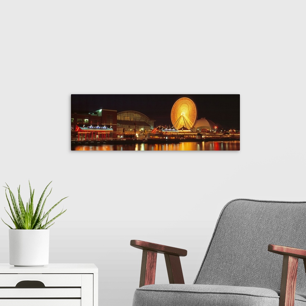 A modern room featuring Panoramic photo on canvas of the navy pier lit up at night along a waterfront with a ferris wheel.