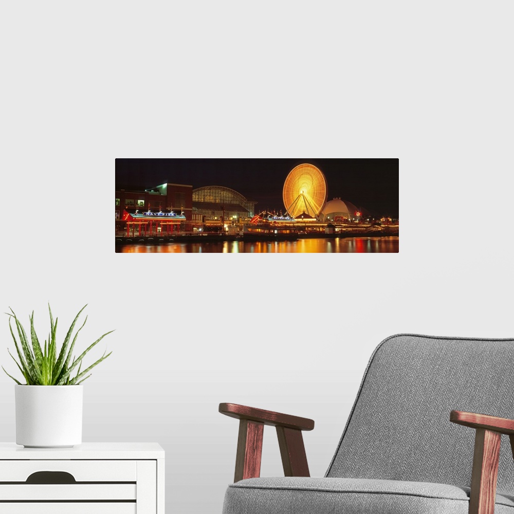 A modern room featuring Panoramic photo on canvas of the navy pier lit up at night along a waterfront with a ferris wheel.