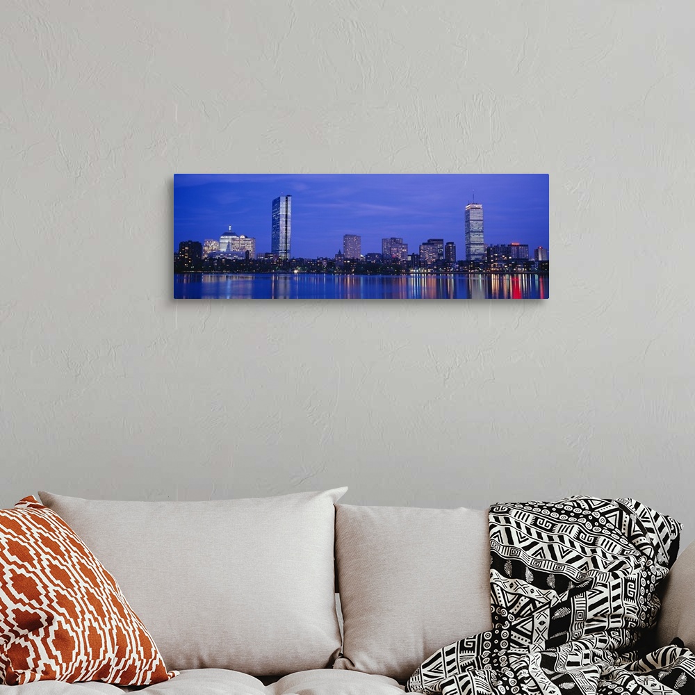 A bohemian room featuring Panoramic night skyline with building lights reflecting onto the waterfront.