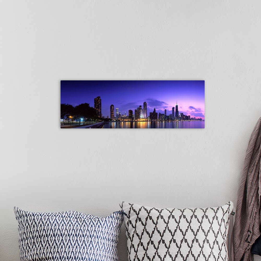 A bohemian room featuring A panoramic of the Chicago cityscape lit up at dusk and reflecting on Lake Michigan.