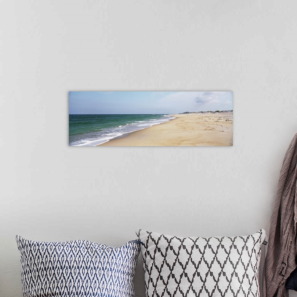 A bohemian room featuring Panoramic photograph displays the Atlantic Ocean slowly coming into contact with a sandy shorelin...