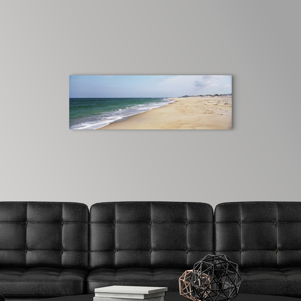 A modern room featuring Panoramic photograph displays the Atlantic Ocean slowly coming into contact with a sandy shorelin...