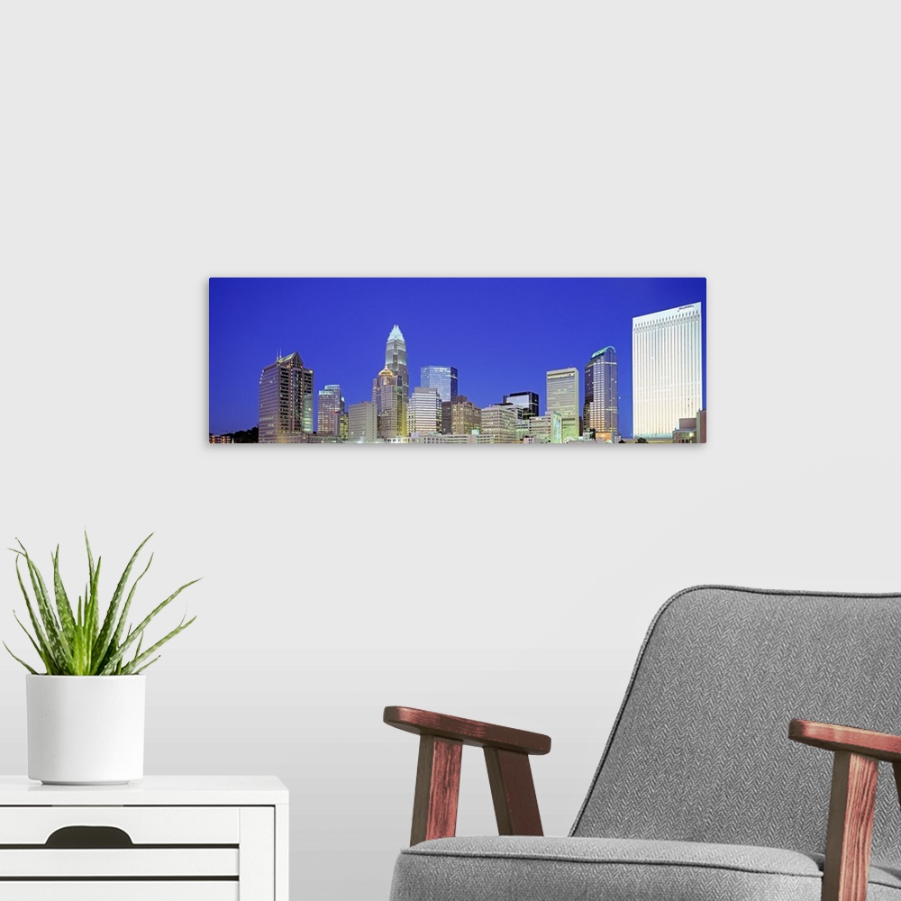 A modern room featuring A night cityscape panorama of Charlotte, North Carolina.
