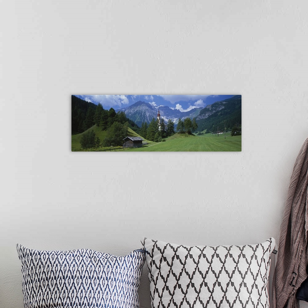 A bohemian room featuring Large canvas print of rugged mountains in the background of a countryside field with a barn, fenc...