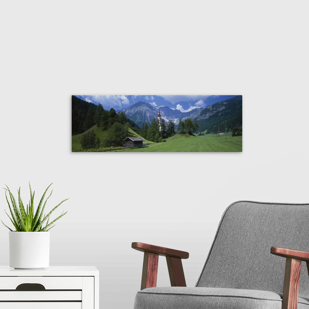 A modern room featuring Large canvas print of rugged mountains in the background of a countryside field with a barn, fenc...