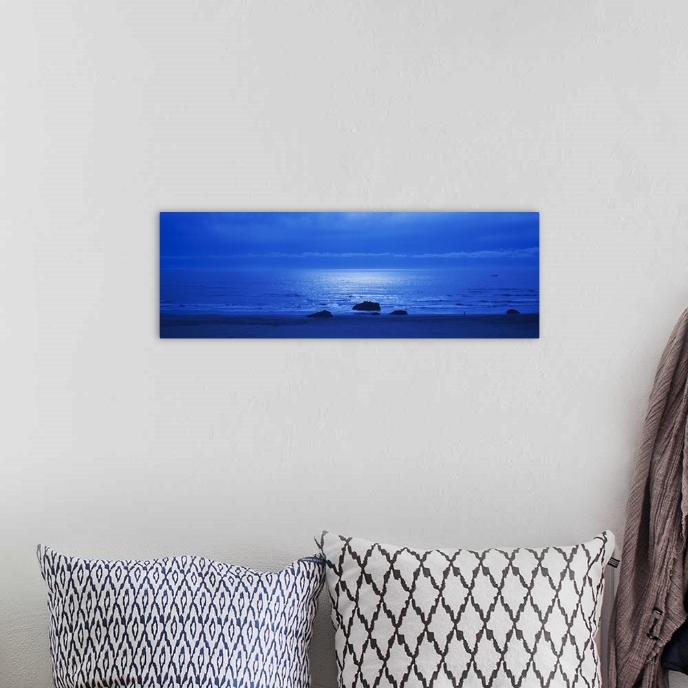 A bohemian room featuring Panoramic photograph of a monotone seascape with the moonlight reflecting off the waves, three so...