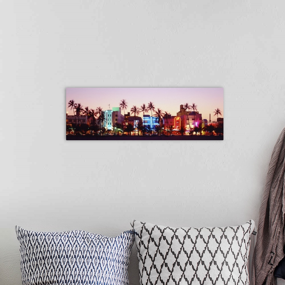 A bohemian room featuring A panoramic photograph of a sunset featuring Miami's Ocean Drive and the neon lights of the Art D...
