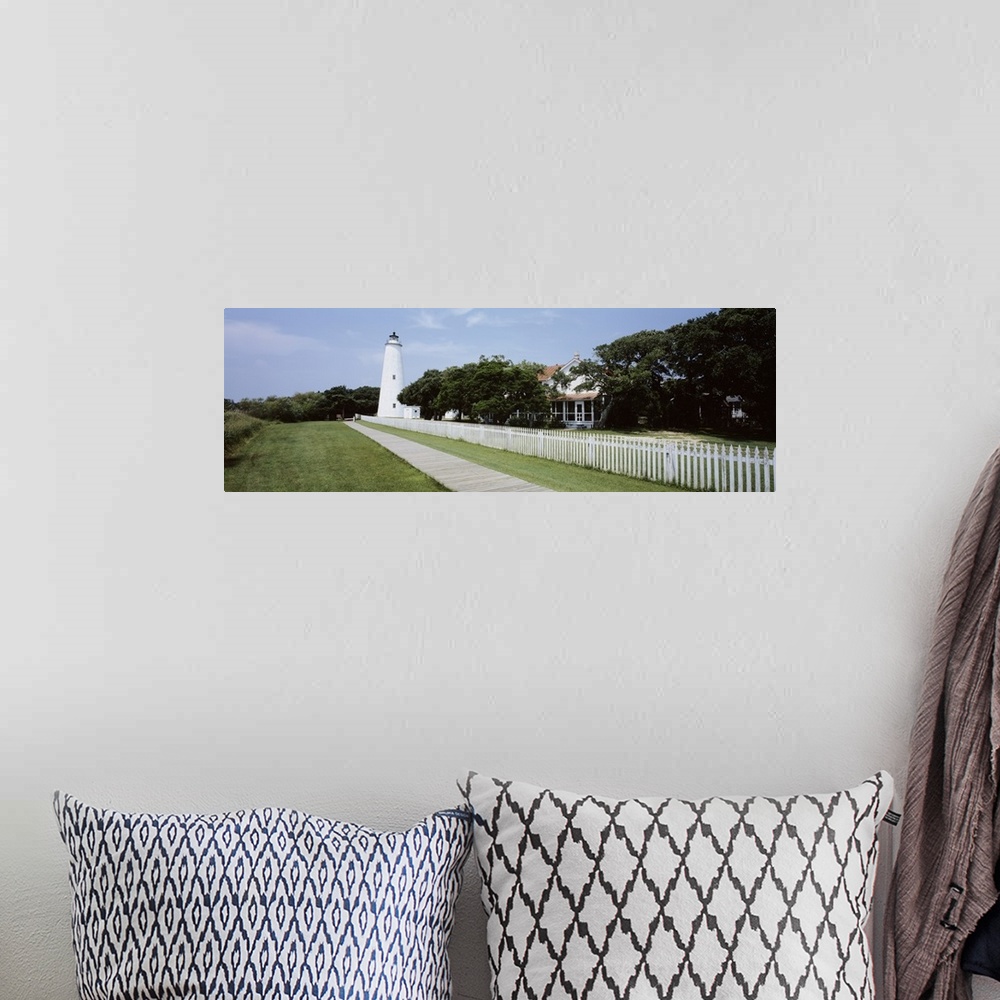 A bohemian room featuring Horizontal photograph on a big canvas of a thin boardwalk and fence leading to a lighthouse surro...