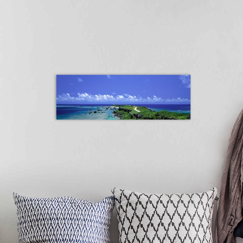A bohemian room featuring Panoramic photograph of peninsula stretching into ocean under a cloudy sky.