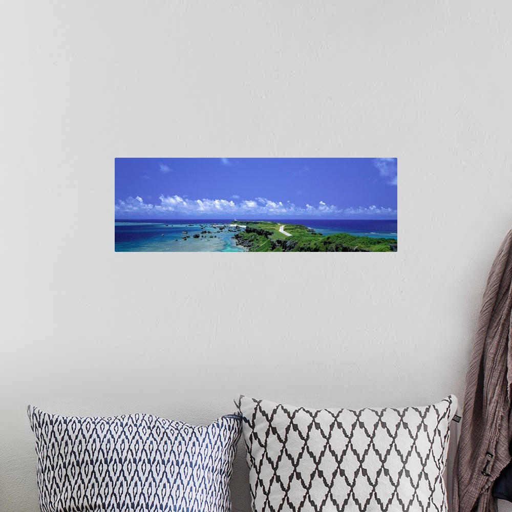 A bohemian room featuring Panoramic photograph of peninsula stretching into ocean under a cloudy sky.