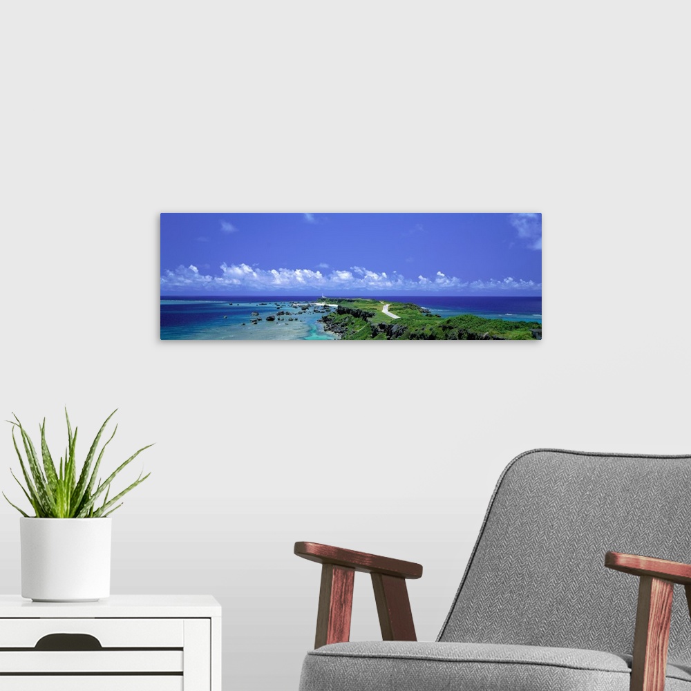 A modern room featuring Panoramic photograph of peninsula stretching into ocean under a cloudy sky.