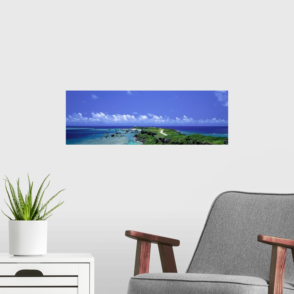 A modern room featuring Panoramic photograph of peninsula stretching into ocean under a cloudy sky.