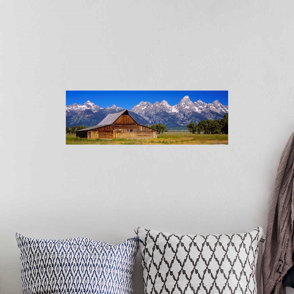 A bohemian room featuring A panoramic landscape photograph of farmland, the T.A. Moulton barn, and the massive mountain pea...
