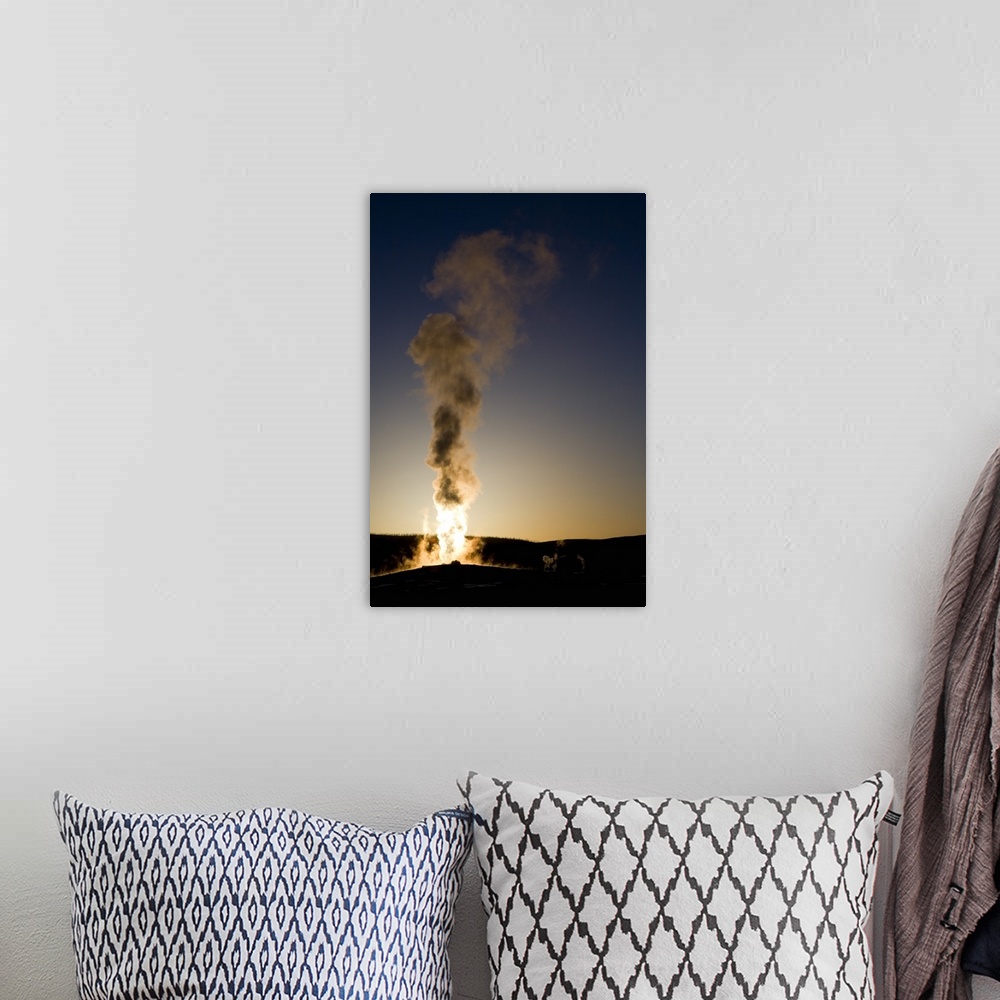 A bohemian room featuring Portrait photograph on a big wall hanging of steam rising into the air as Old Faithful erupts as ...