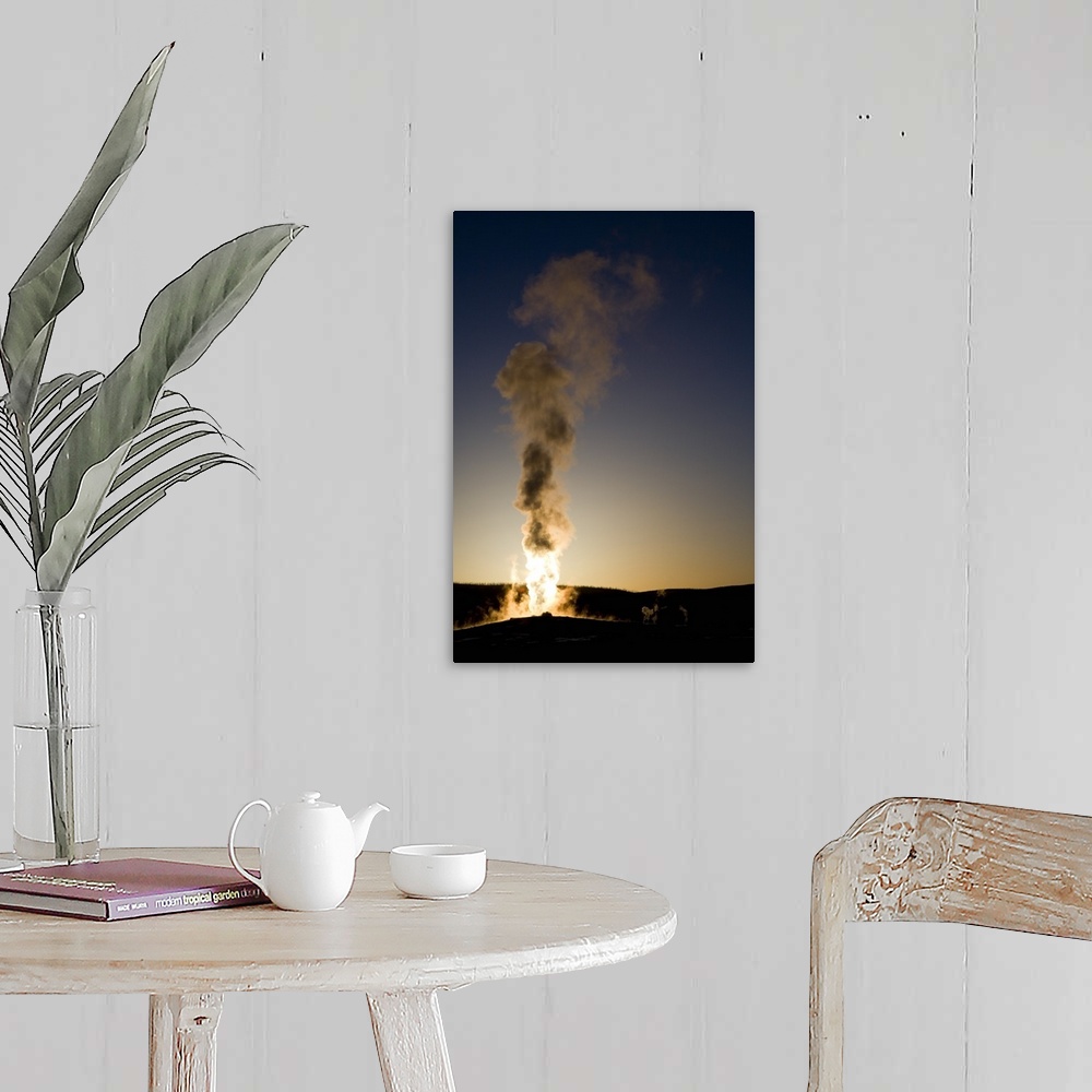 A farmhouse room featuring Portrait photograph on a big wall hanging of steam rising into the air as Old Faithful erupts as ...