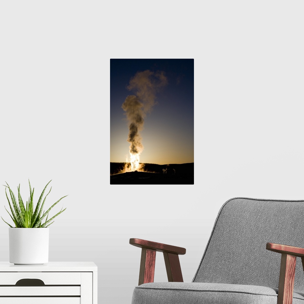 A modern room featuring Portrait photograph on a big wall hanging of steam rising into the air as Old Faithful erupts as ...