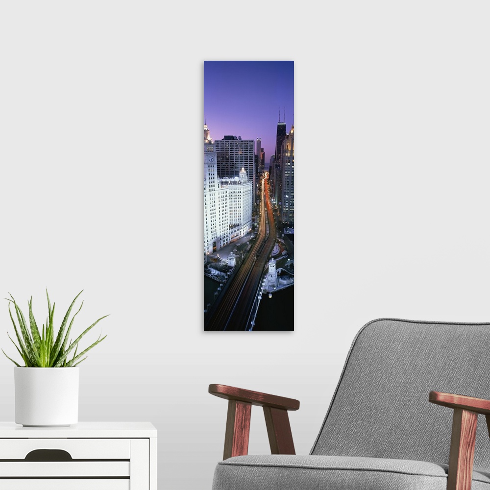 A modern room featuring A photograph of a busy street going through downtown Chicago at night with the lights of the cars...