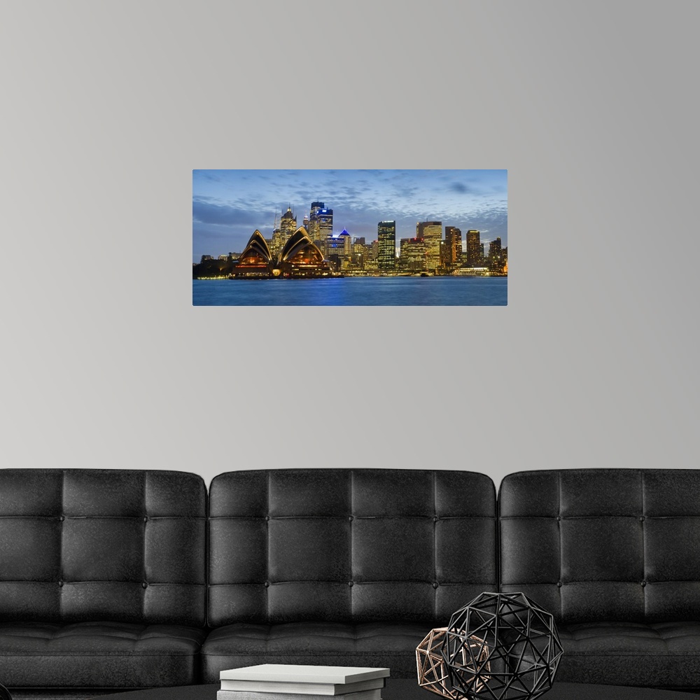 A modern room featuring Panoramic photograph taken at nighttime displays the brightly lit skyline and surrounding structu...