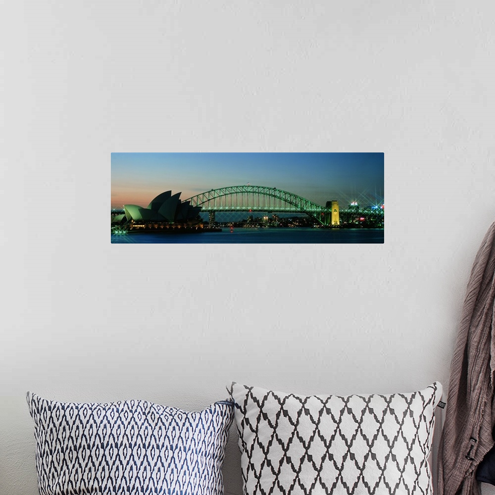 A bohemian room featuring Long horizontal canvas of the Opera House in Sydney lit up at dusk with a bridge running behind it.